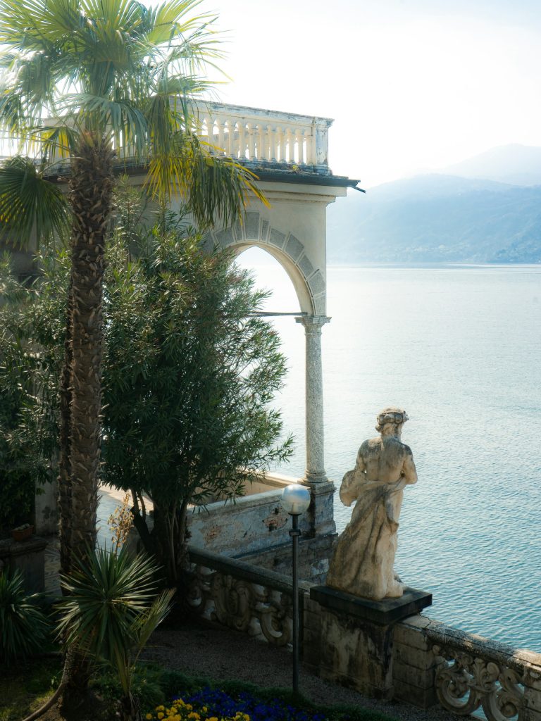 Olive tree and palm tree, covered terrace and sculpture facing Lake Como