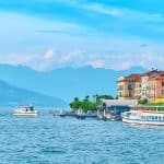 Beautiful sunny summer view of Bellagio town at lake Como in Italy with blooming nerium oleander flowers, ships and boats