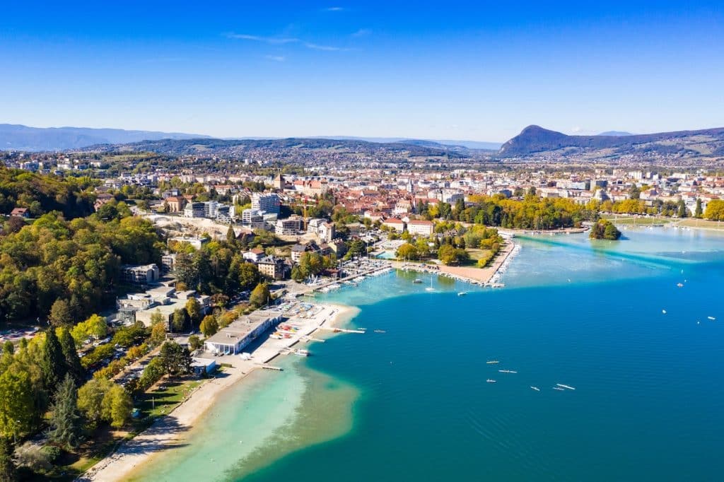 Aerial view of Lake Annecy's turquoise waters and waterfront hotels in Annecy, French Alps